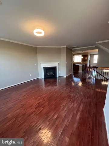 an empty room with wooden floor and a fireplace