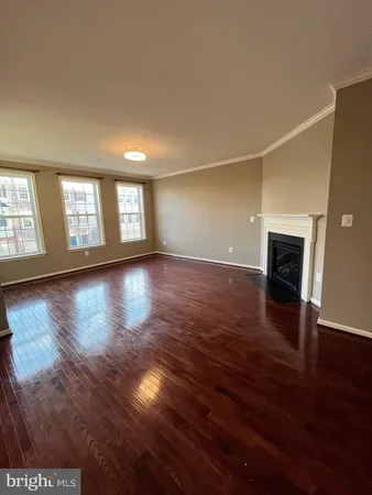 a view of a livingroom with wooden floor and a fireplace