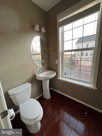 a bathroom with a toilet sink a mirror and a window