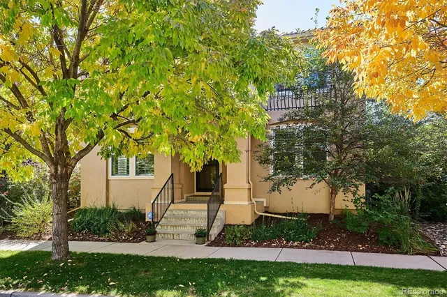 a front view of a house with a yard and trees