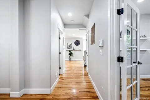 a view of a hallway with wooden floor and staircase