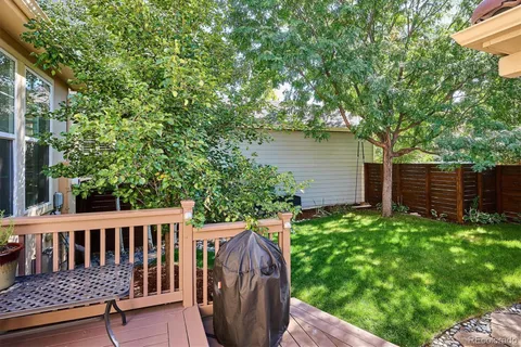 a view of a wooden deck with a bench and trees