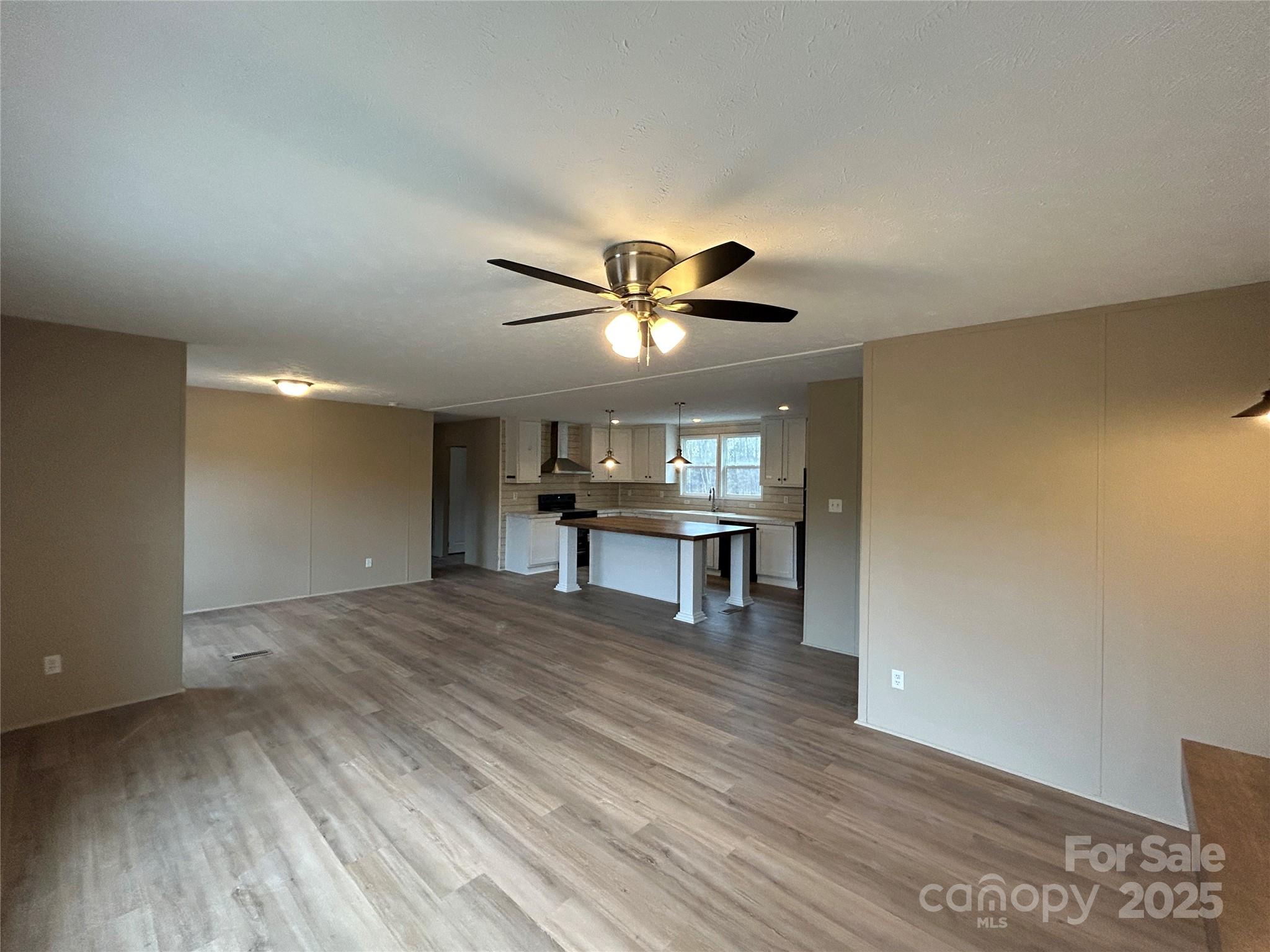 4765 Logging Road Lancaster, SC 29720 - Photo 4 of 19 a view of an empty room with a ceiling fan and wooden floor