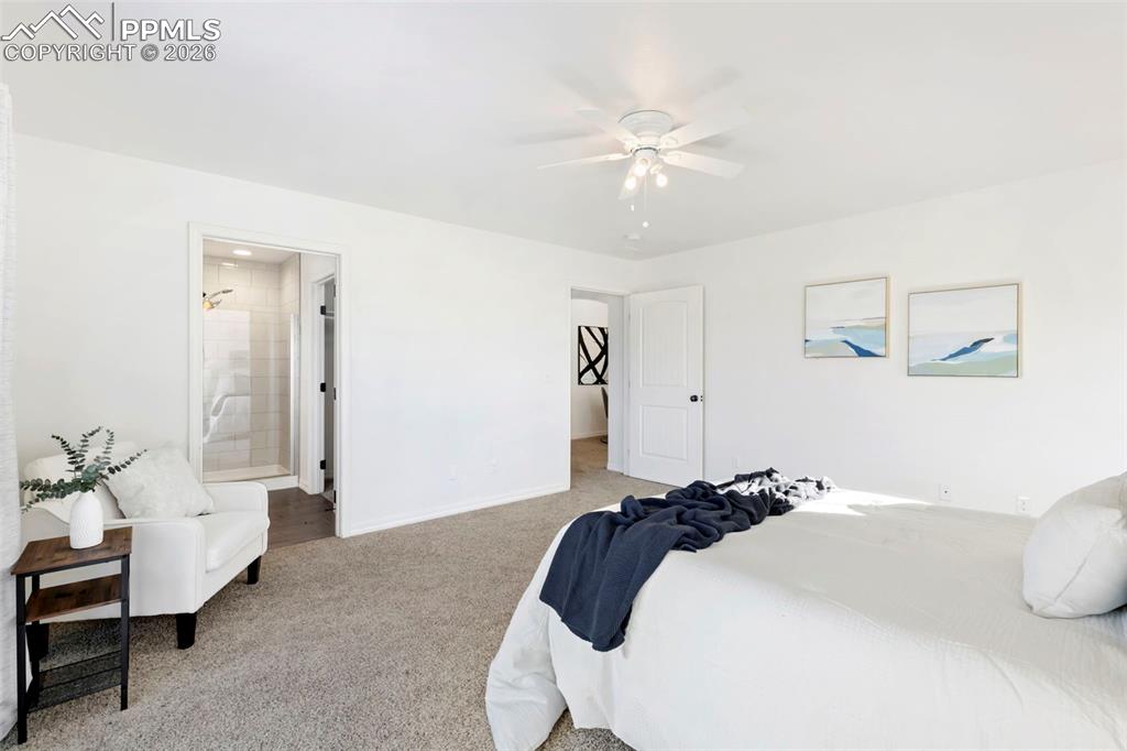 6528 Watusi Road Peyton, CO 80831 - Photo 15 of 27 a bed room with a bed and a chandelier
