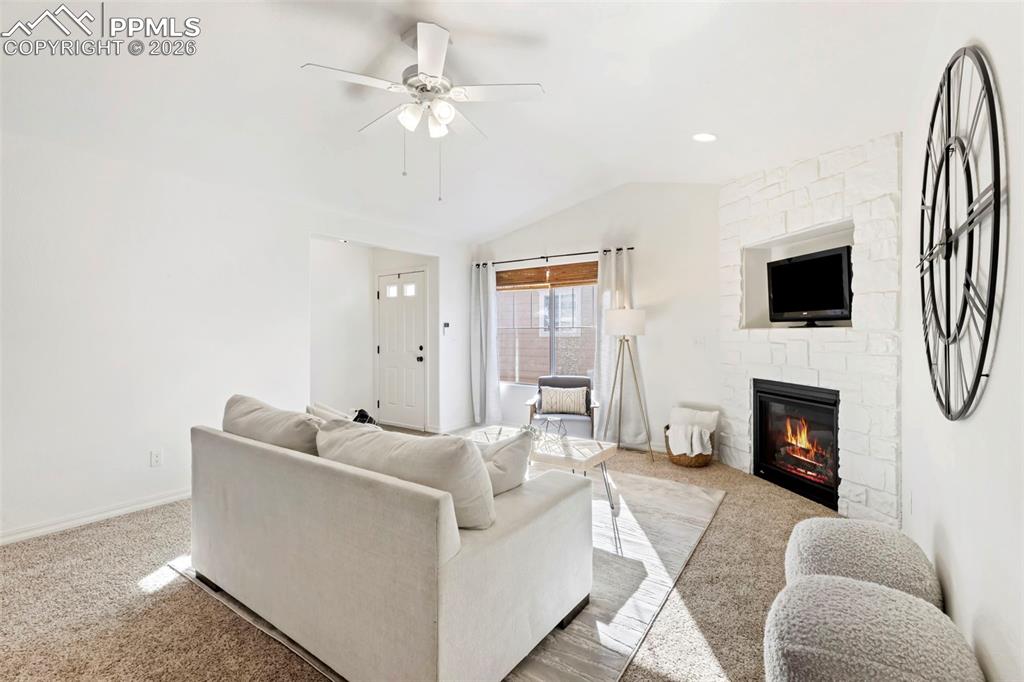 6528 Watusi Road Peyton, CO 80831 - Photo 3 of 27 a living room with furniture a fireplace and a flat screen tv