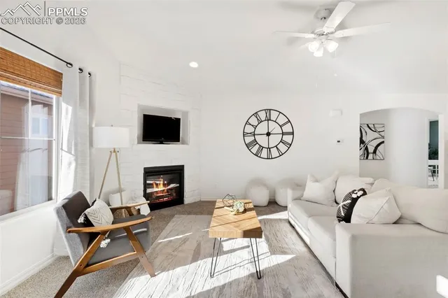 a living room with furniture a fireplace and a window