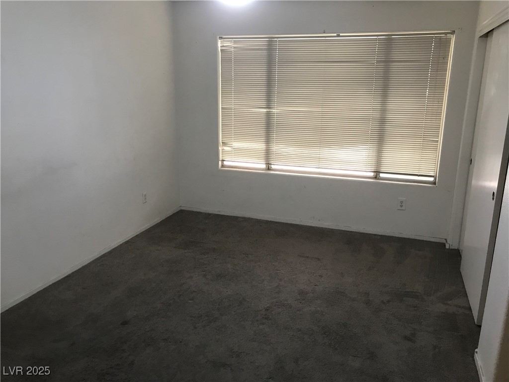 3425 East Russell Road, Unit 170 Las Vegas, NV 89120 - Photo 12 of 13 Spare room featuring dark carpet and baseboards