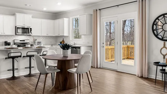 a kitchen with stainless steel appliances granite countertop a table and chairs in it