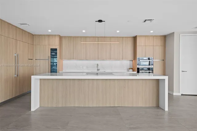 a kitchen with stainless steel appliances granite countertop a sink and a refrigerator