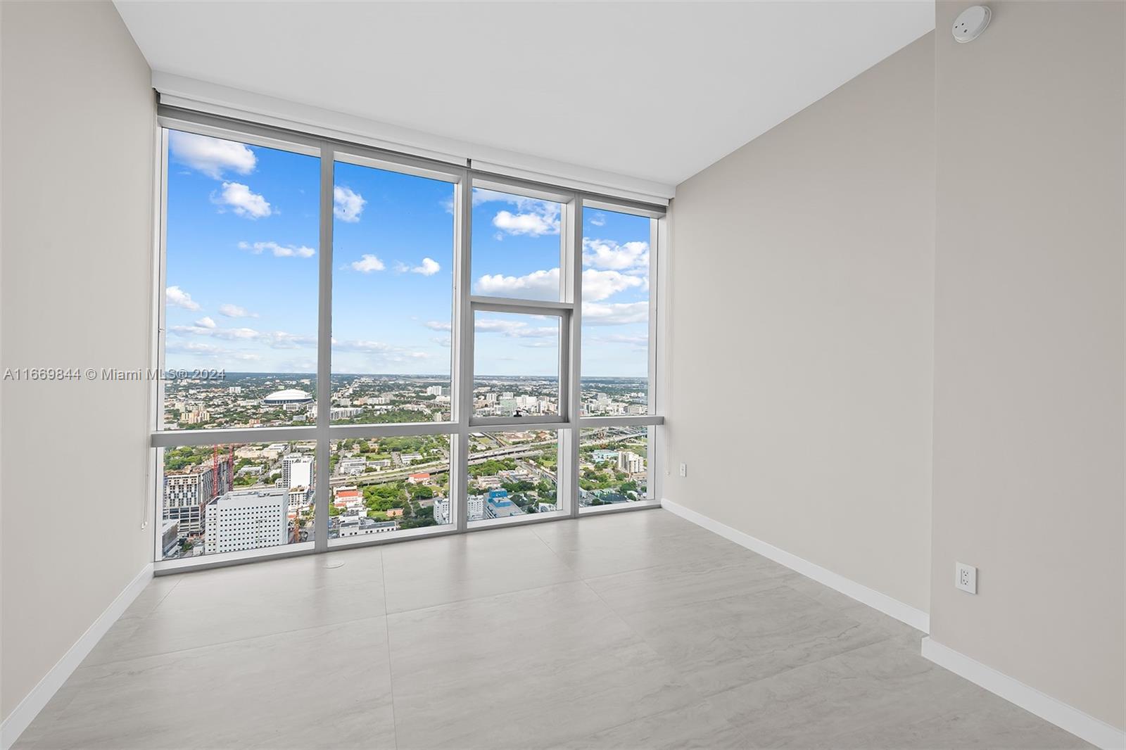 851 Northeast 1st Avenue, Unit PH5412 Miami, FL 33132 - Photo 27 of 65 an empty room with wooden floor and windows