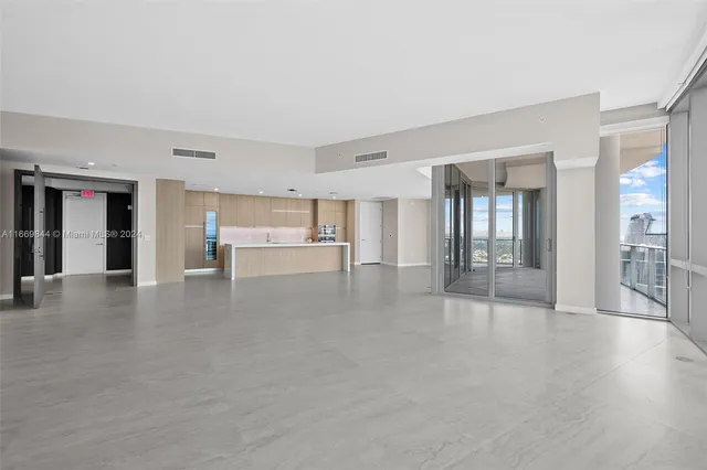 a view of kitchen with kitchen island wooden floor center island stainless steel appliances and cabinets