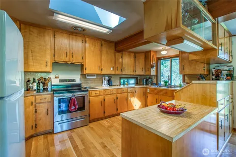 a kitchen with stainless steel appliances granite countertop a sink a stove and a refrigerator