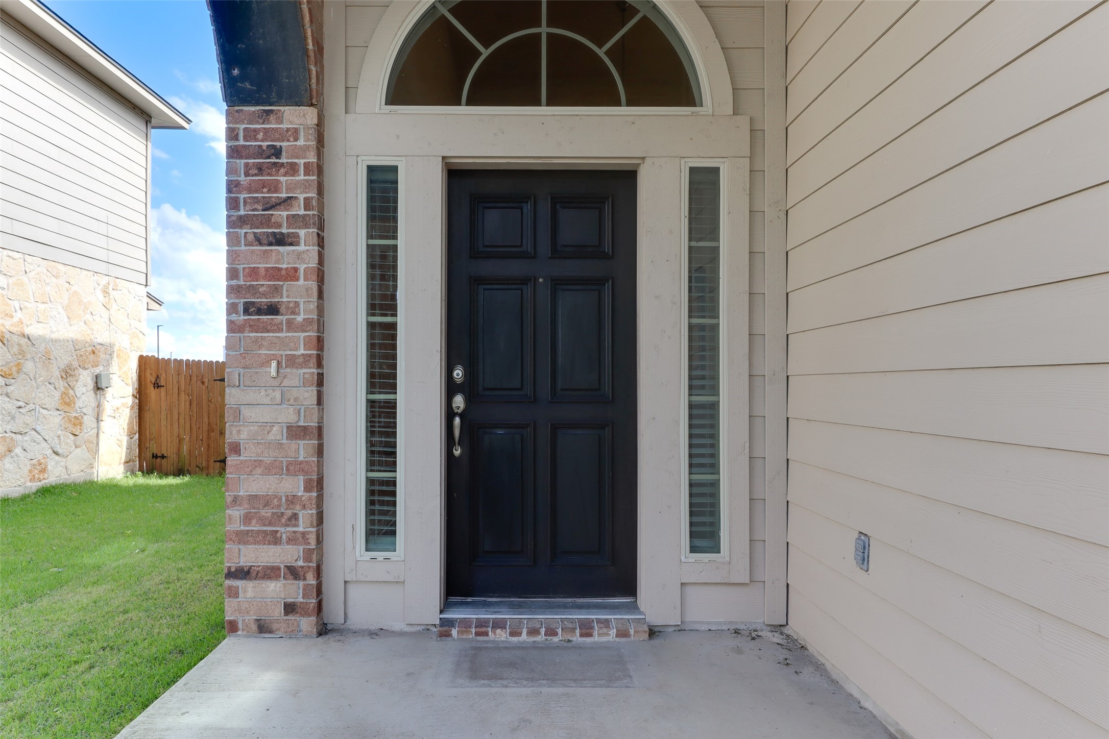 18705 Moreto Loop Pflugerville, TX 78660 - Photo 3 of 21 A classic dark entry door welcomes guests, flanked by sidelight windows and topped with an arched transom.