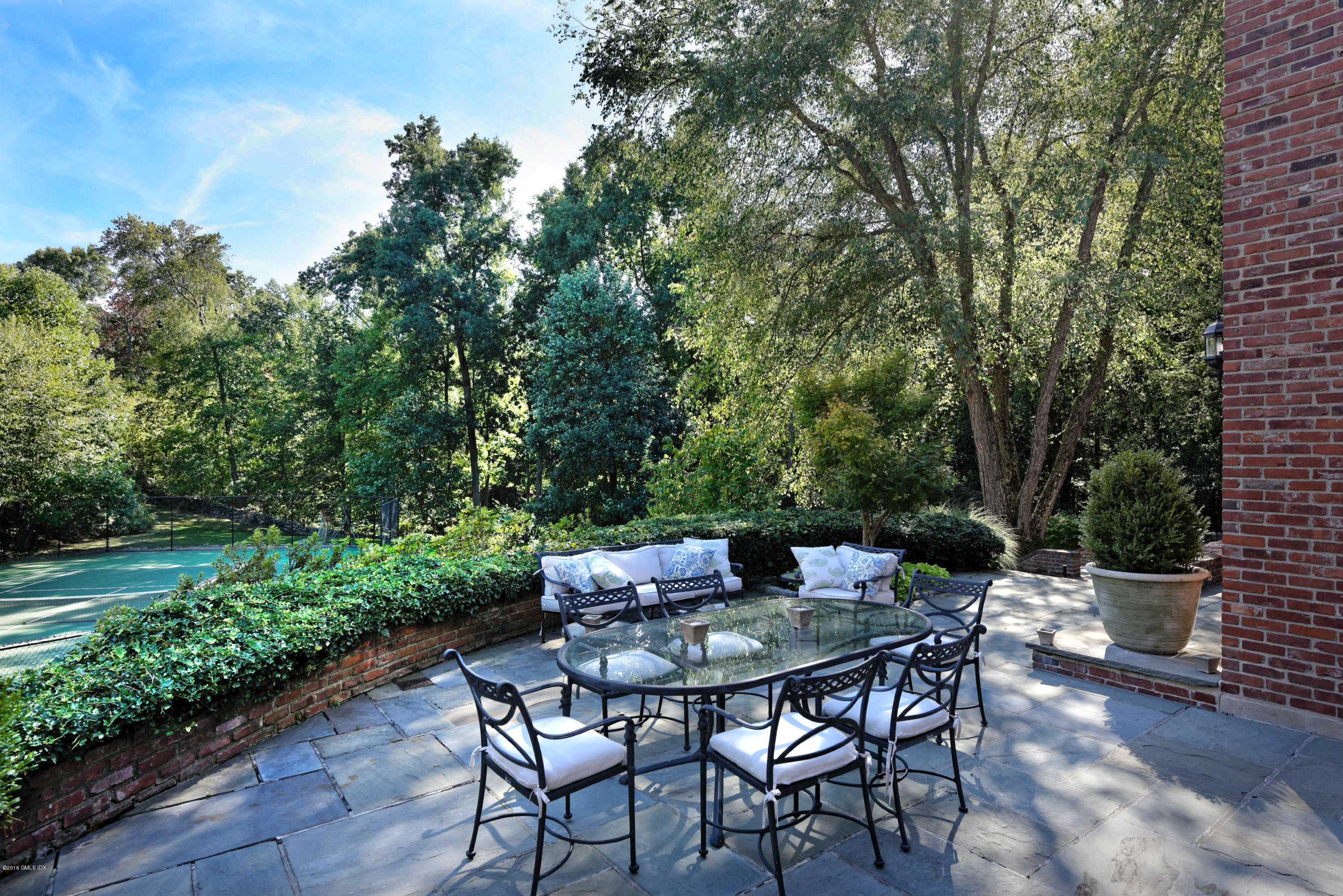 46 Quail Road Greenwich, CT 06831 - Photo 18 of 22 a backyard of a house with table and chairs