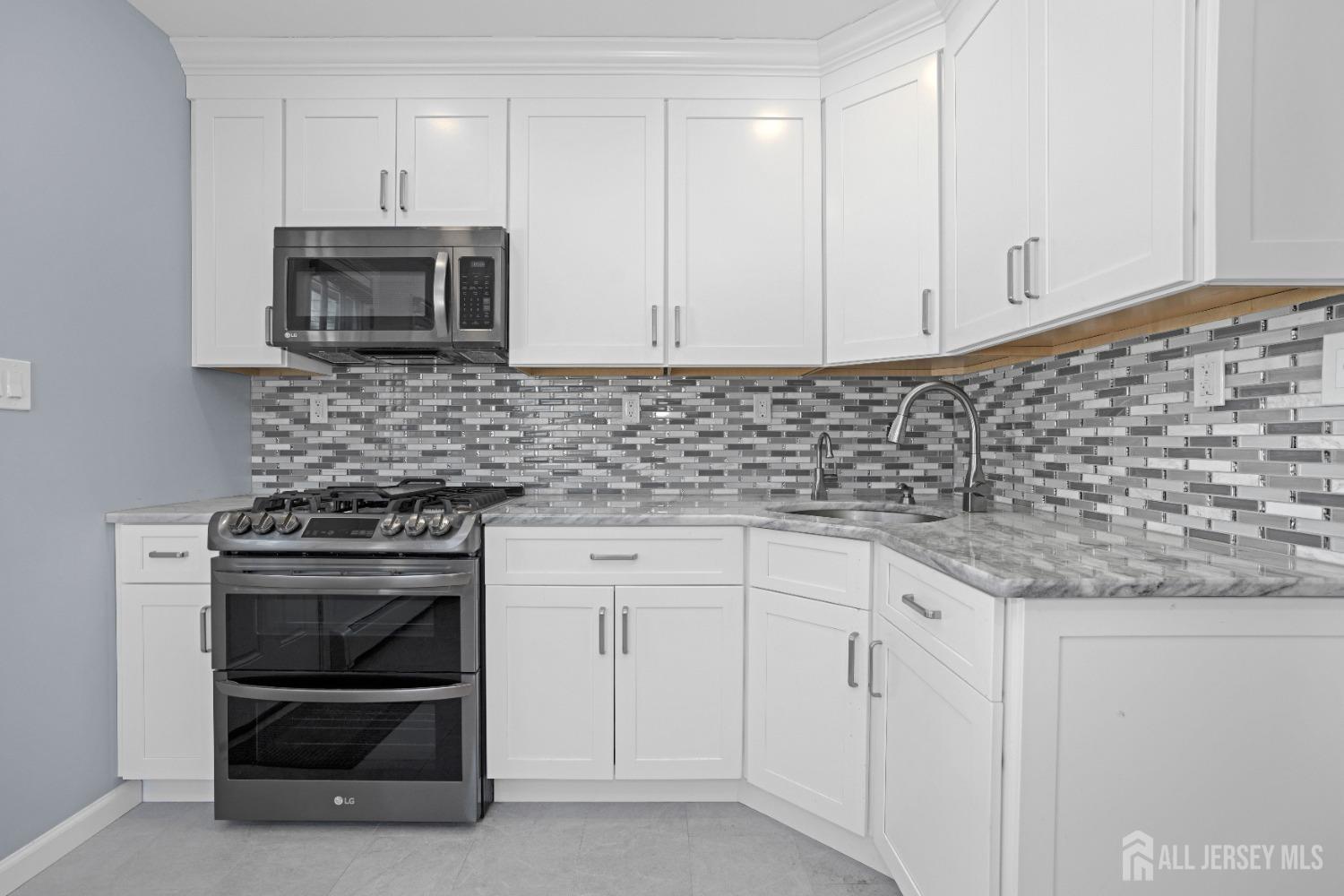 52 Markham Road Edison, NJ 08817 - Photo 11 of 28 a kitchen with granite countertop white cabinets and stainless steel appliances