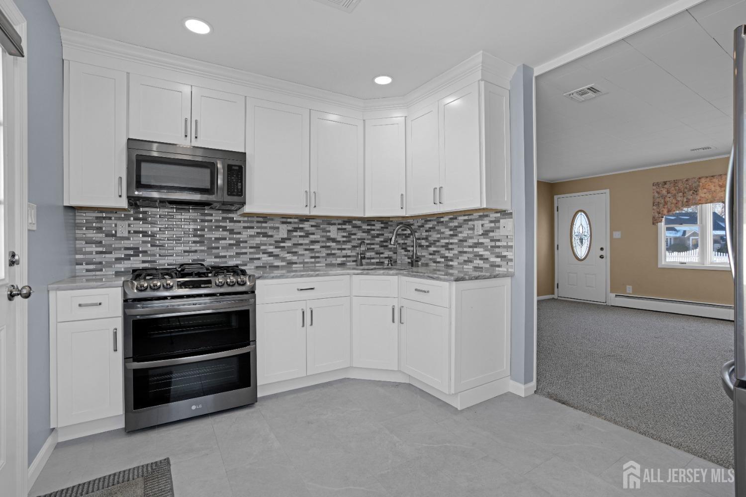 52 Markham Road Edison, NJ 08817 - Photo 9 of 28 a kitchen with stainless steel appliances granite countertop a stove a microwave and a sink