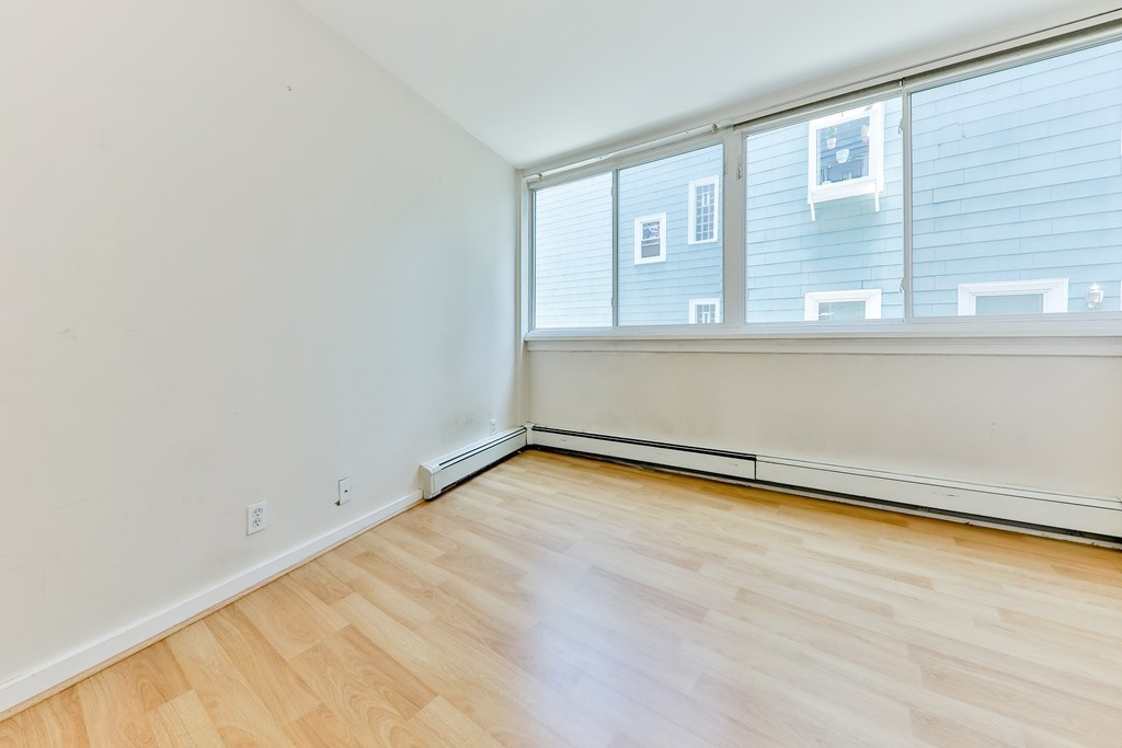 512-516 Green Street, Unit 1D Cambridge, MA 02139 - Photo 6 of 9 a view of empty room with wooden floor and fan