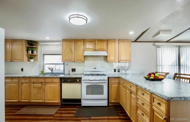 a kitchen with stainless steel appliances granite countertop a sink stove and cabinets