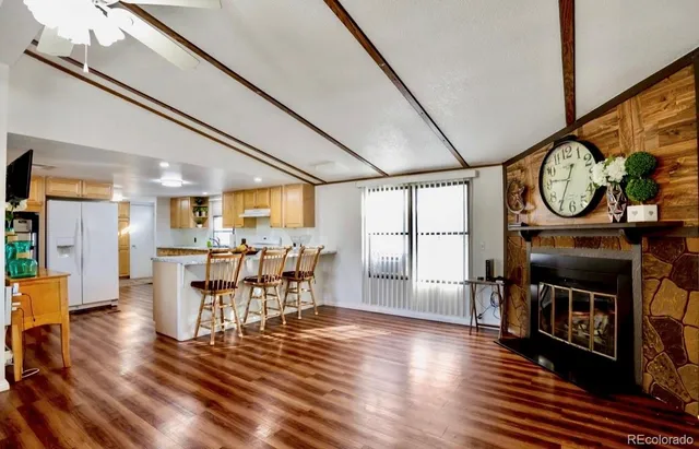 a dining room with furniture a fireplace and wooden floor