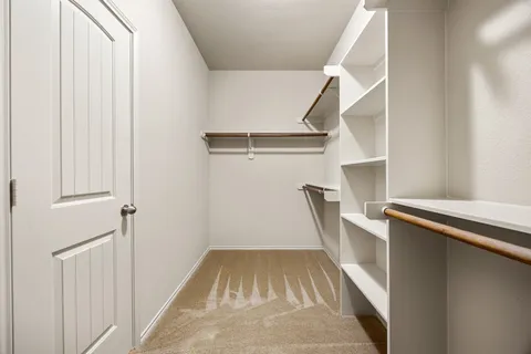 a view of a bedroom with a bed and a window