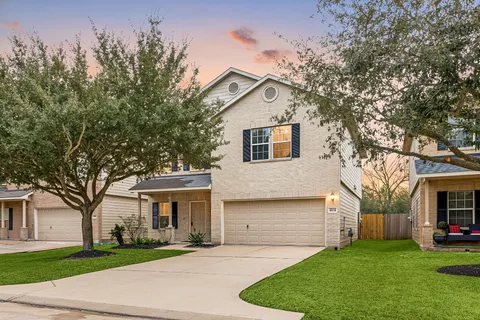 a front view of a house with a yard and trees