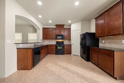 a kitchen with granite countertop stainless steel appliances and refrigerator