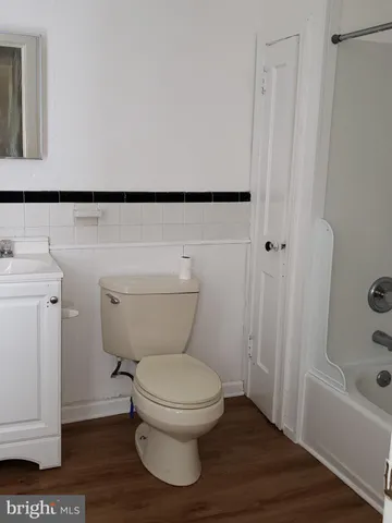 a white toilet sitting next to a bath tub
