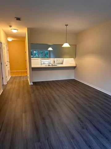 a view of a room with wooden floor fan and window