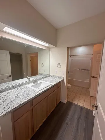 a bathroom with a granite countertop sink and mirror
