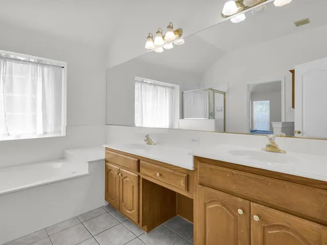 a bathroom with a sink a vanity a mirror and a bathtub