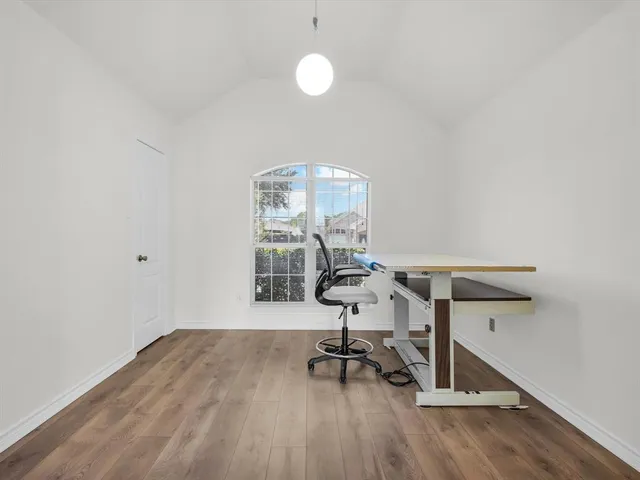 a view of a room with wooden floor table and chairs