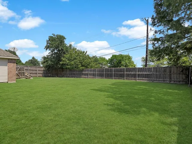 a view of a yard with a wooden fence