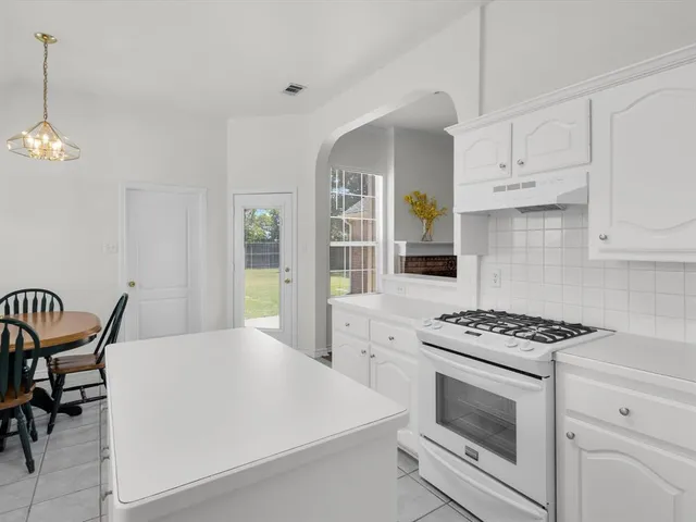 a kitchen with stainless steel appliances a white stove top oven and cabinets