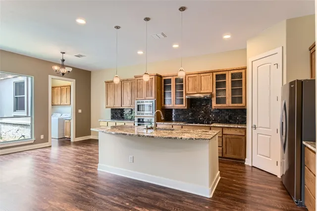 a kitchen with stainless steel appliances granite countertop a sink stove and refrigerator