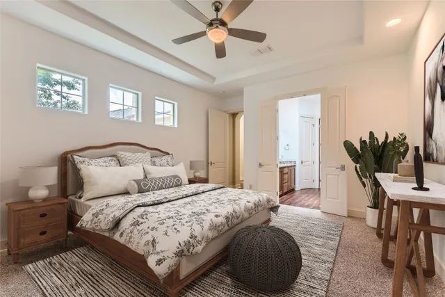a bedroom with a large bed a chandelier and a potted plant on the dresser