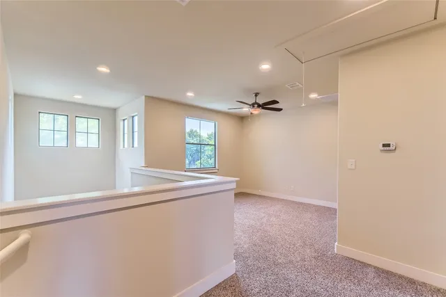 a view of empty room with window and wooden floor