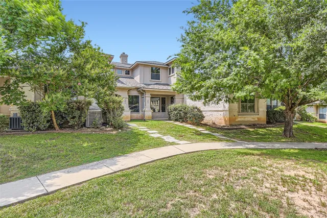 a view of a house with a big yard and large trees