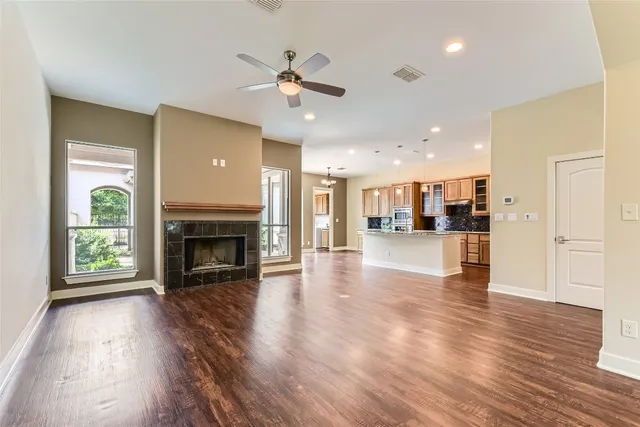 a view of a livingroom with a fireplace wooden floor and a window