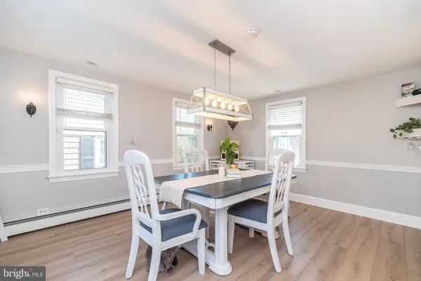 a dining room with furniture a chandelier and wooden floor