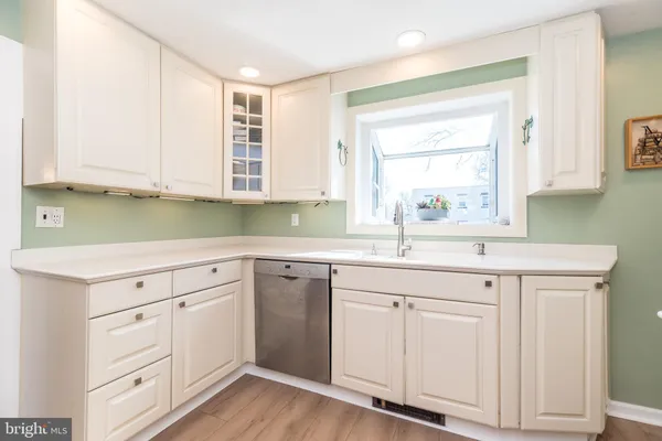 a kitchen with white cabinets and sink