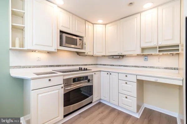 a kitchen with granite countertop white cabinets and white appliances