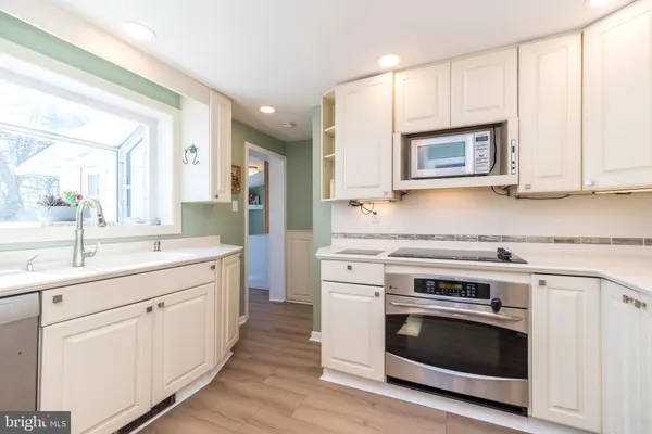 a kitchen with white cabinets and stainless steel appliances