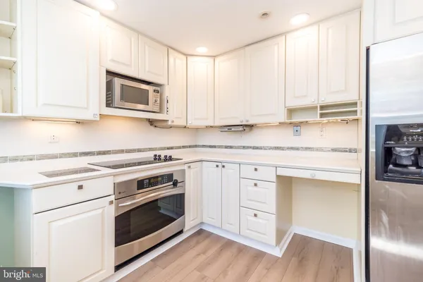 a kitchen with granite countertop white cabinets and white appliances