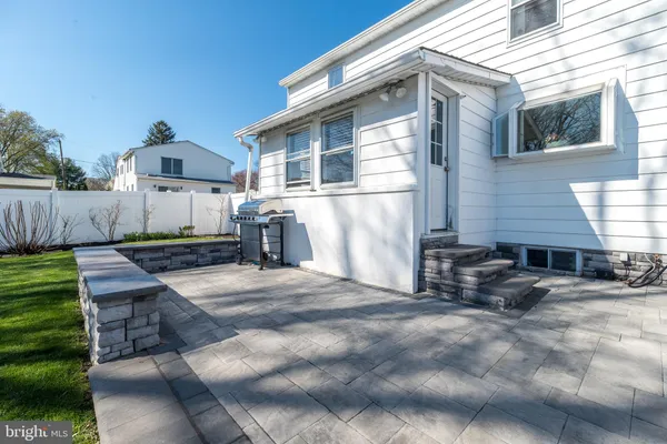 a backyard of a house with entertaining fence and a large tree