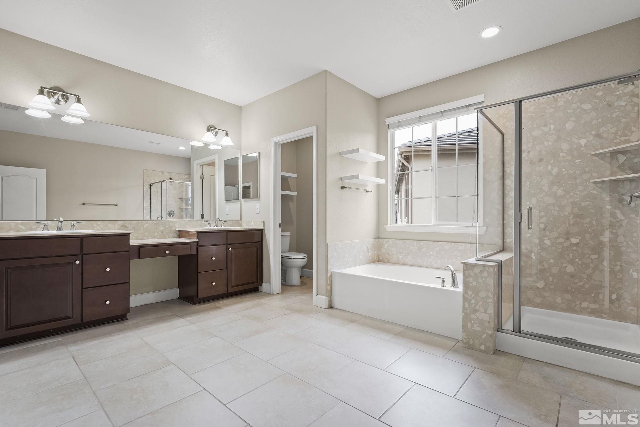 10848 Walnut Ridge Drive Reno, NV 89521 - Photo 16 of 32 a spacious bathroom with a tub sink shower and mirror