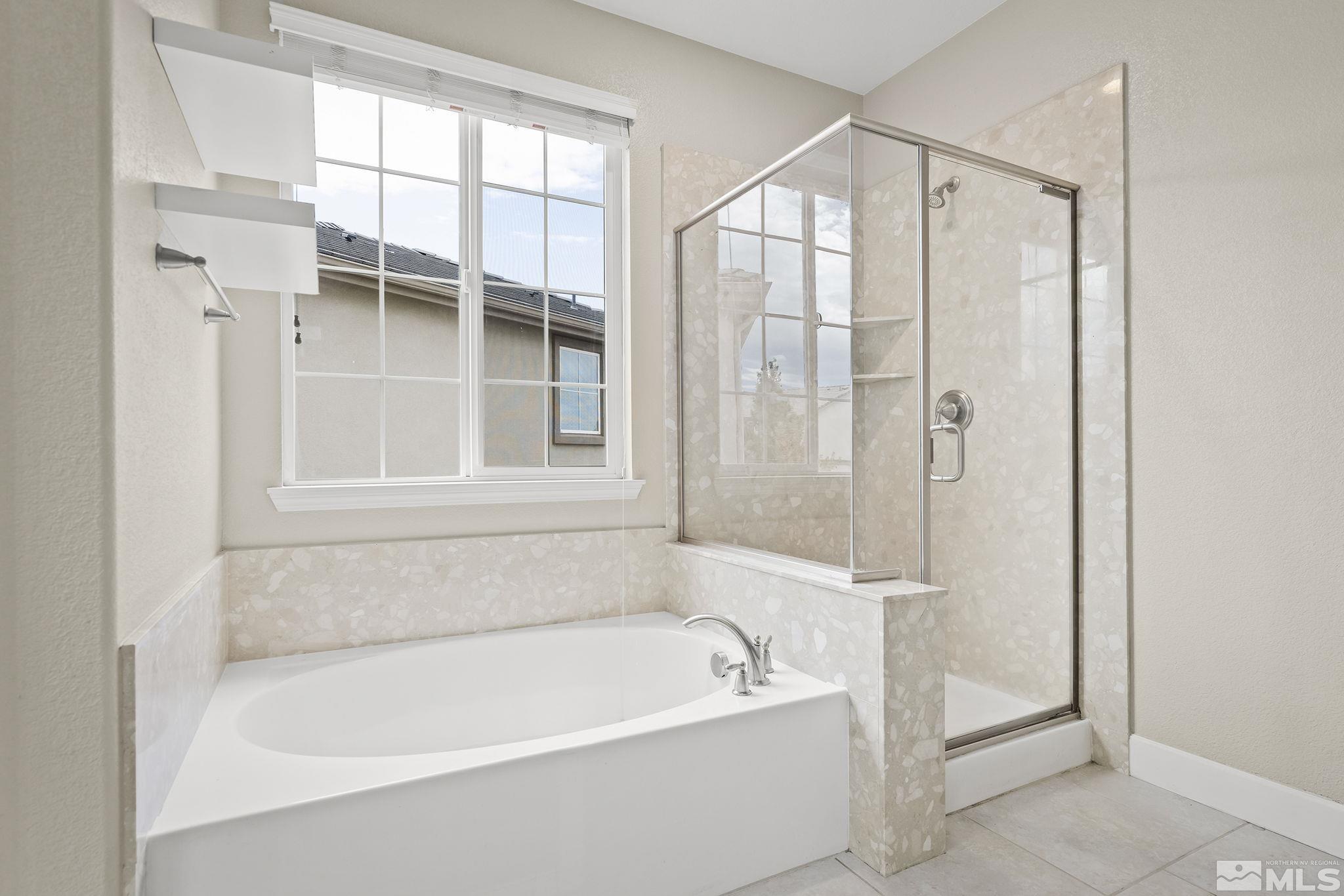 10848 Walnut Ridge Drive Reno, NV 89521 - Photo 17 of 32 a bathroom with a bathtub and a shower