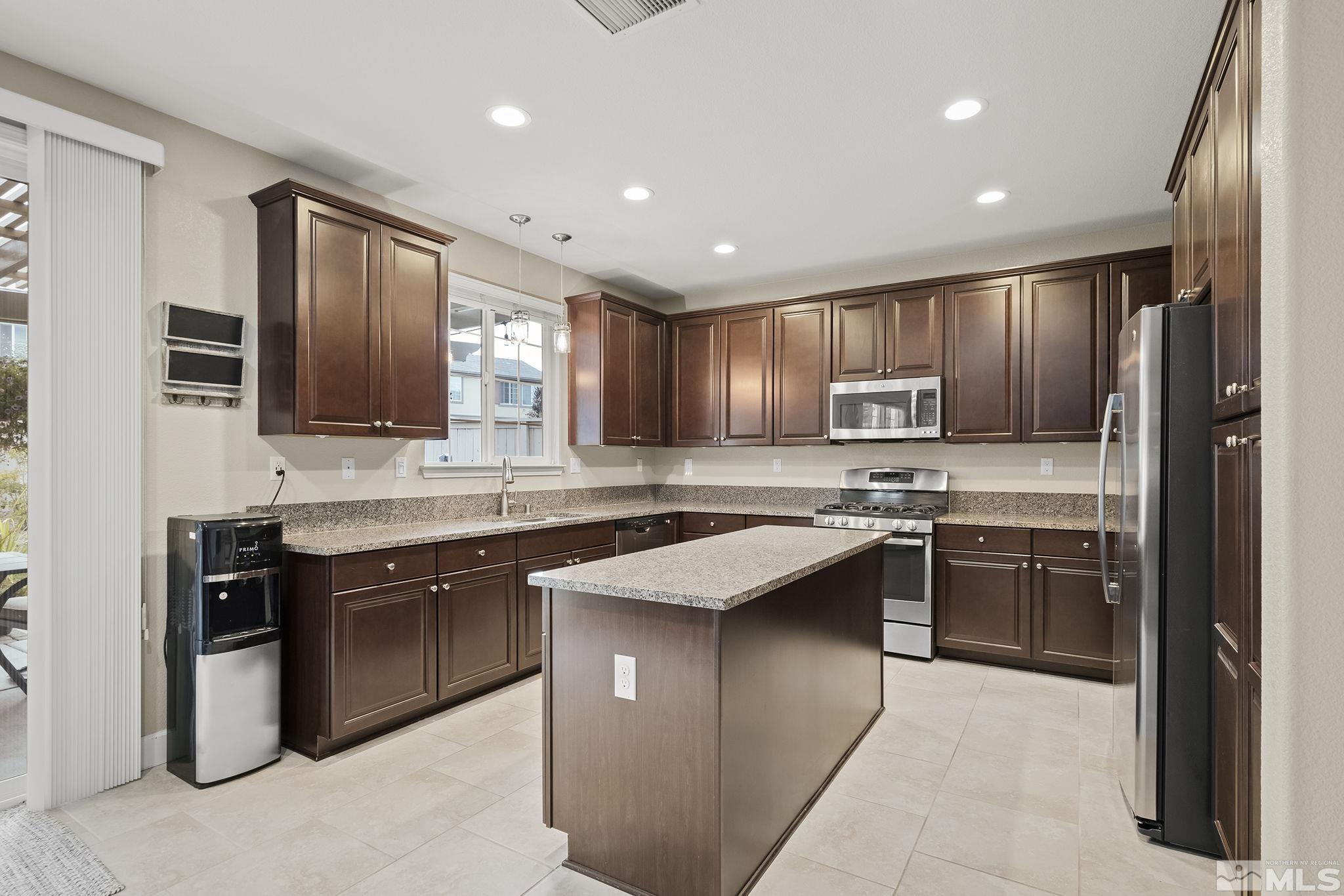 10848 Walnut Ridge Drive Reno, NV 89521 - Photo 10 of 32 a kitchen with stainless steel appliances granite countertop wooden cabinets a sink dishwasher a refrigerator and a stove top oven