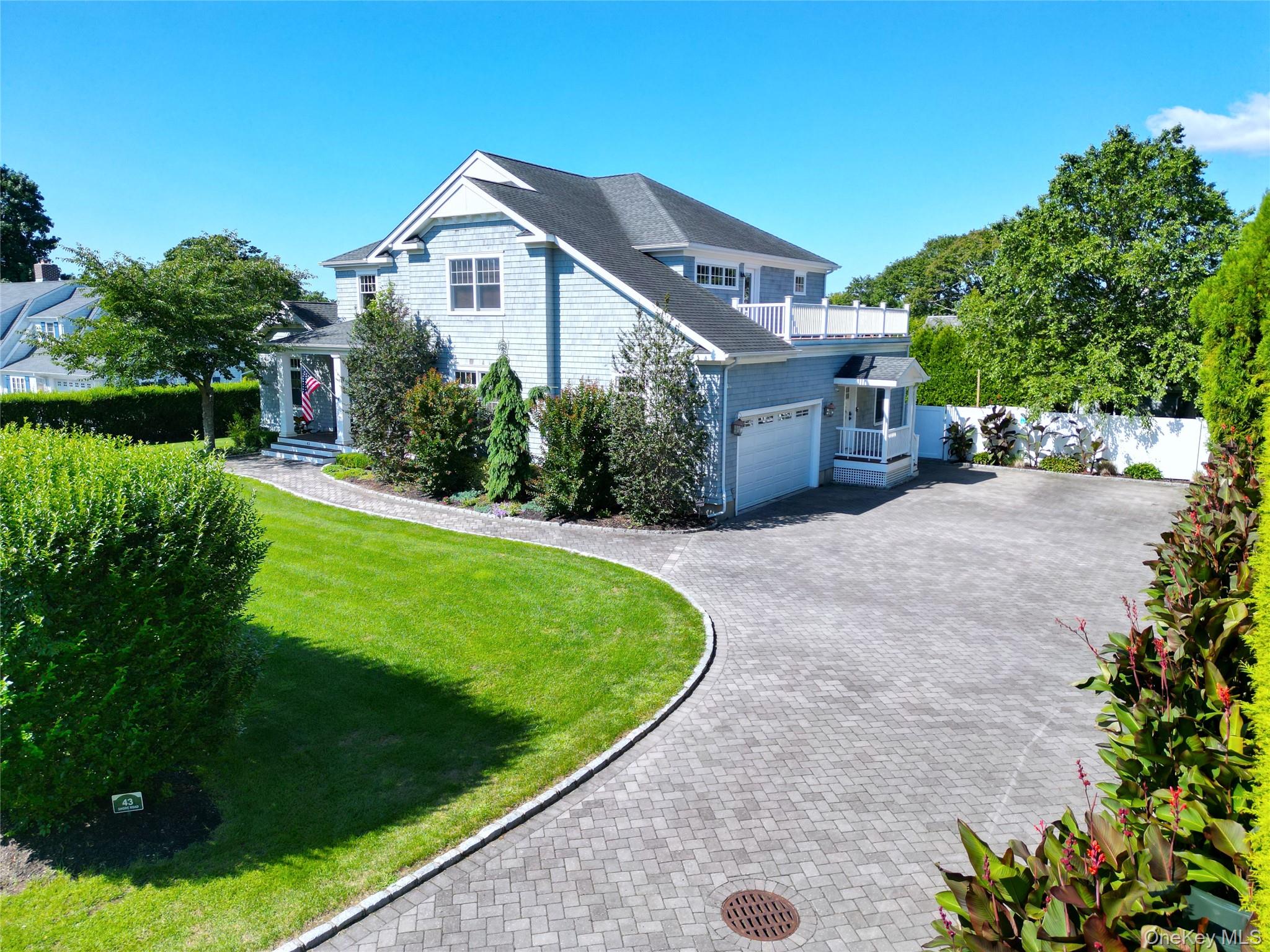 43 Shore Road Remsenburg, NY 11960 - Photo 12 of 28 a front view of a house with a yard and garage