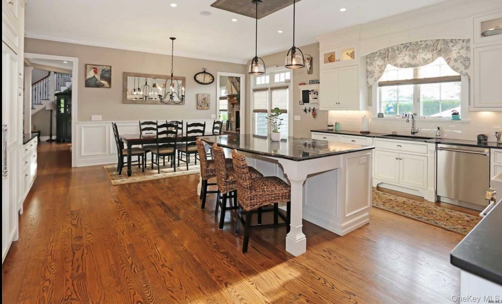 43 Shore Road Remsenburg, NY 11960 - Photo 9 of 28 a kitchen with stainless steel appliances granite countertop a table chairs stove a sink dishwasher and cabinets with wooden floor