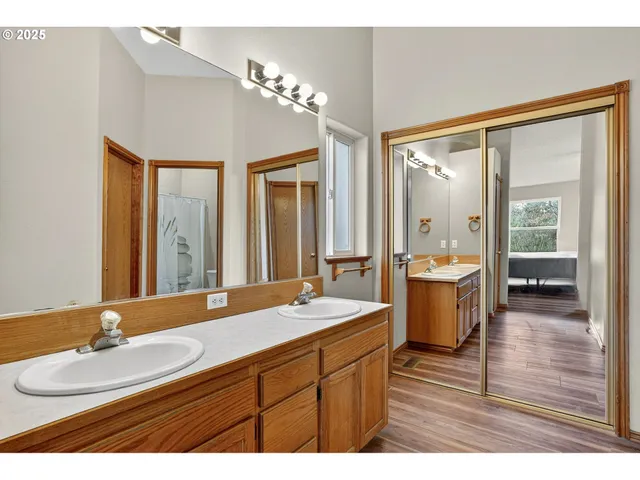 a bathroom with a double vanity sink mirror and bathtub